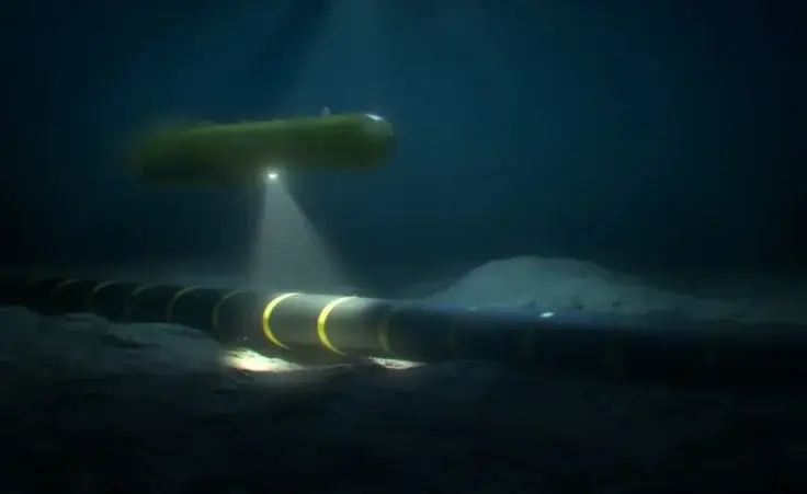Autonomous underwater vehicle (AUV) rover-drone inspecting a submarine internet communication cable on the seabed in the ocean. By Jesper/stock.adobe.com