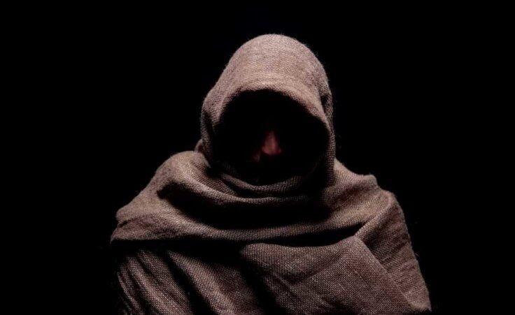 An anonymous prophet in a brown hooded cloak.