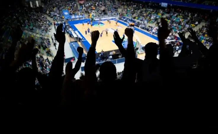 Silhouette of a group of spectators at a professional basketball game cheering for their team By Nektarstock/stock.adobe.com