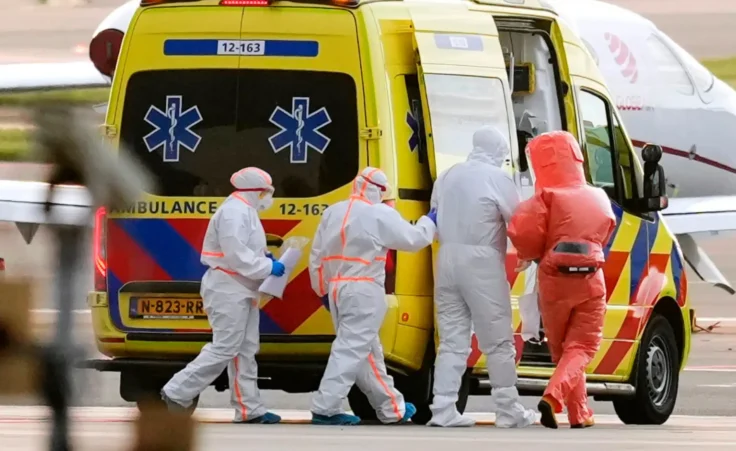 Medics escort a patient, second right, evacuated from the MV Hondius cruise ship with suspected hantavirus infection, to an ambulance after being flown to Schiphol airport, Amsterdam, Netherlands, Wednesday, May 6, 2026. (AP Photo/Peter Dejong)