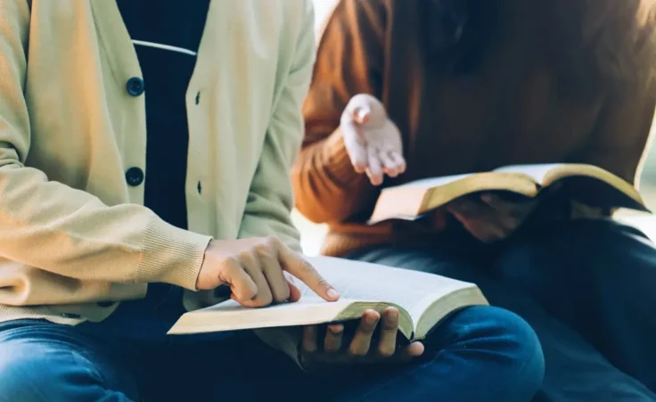 Christian Bible Study Concepts. Christian friends read and study the bible together in the park. followers are studying the word of God in churches. sharing the gospel with a friend. Education By Pcess609/stock.adobe.com