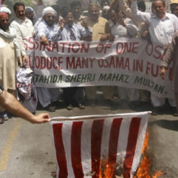 Supporters of al Qaeda leader Osama bin Laden, who was killed on Monday in a U.S. special forces assault on a Pakistani compound, burn a replica of a U.S. flag during a rally of more than 100 people in Multan May 4, 2011. (Credit: Reuters/Stringer)