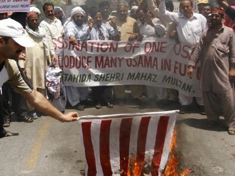 Supporters of al Qaeda leader Osama bin Laden, who was killed on Monday in a U.S. special forces assault on a Pakistani compound, burn a replica of a U.S. flag during a rally of more than 100 people in Multan May 4, 2011. (Credit: Reuters/Stringer)