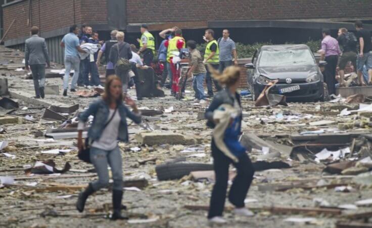 Two women are seen leaving as rescue workers arrive to evacuate the injured at the site of a powerful explosion that rocked central Oslo July 22, 2011. (Credit: Reuters / Thomas Winje Oijord)