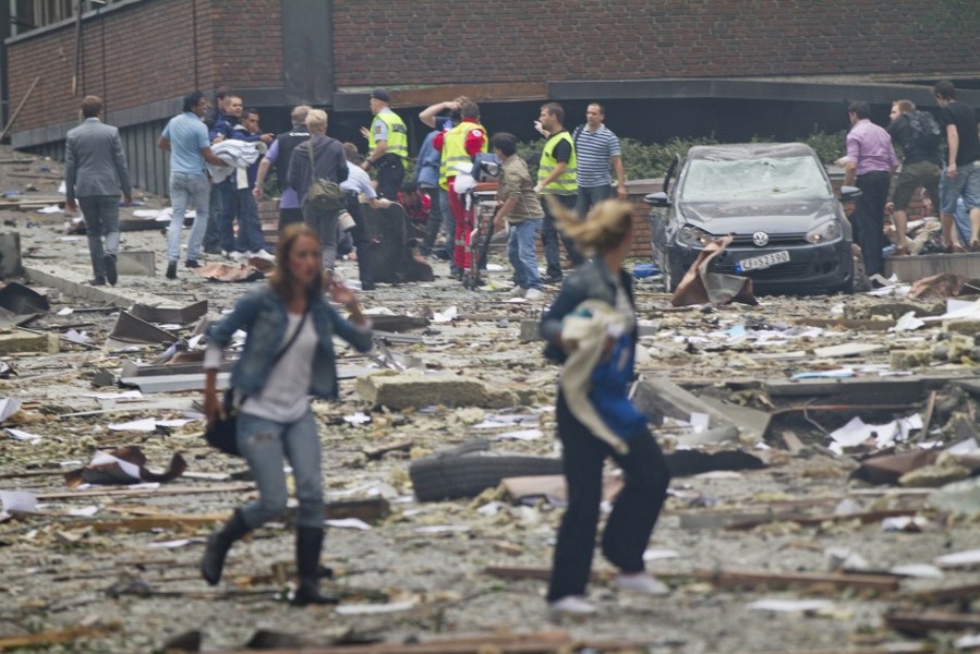 Two women are seen leaving as rescue workers arrive to evacuate the injured at the site of a powerful explosion that rocked central Oslo July 22, 2011. (Credit: Reuters / Thomas Winje Oijord)