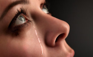 A young sad girl with a tear rolling down her cheek looking up to God (Credit: Chepko Danil via Fotolia.com)