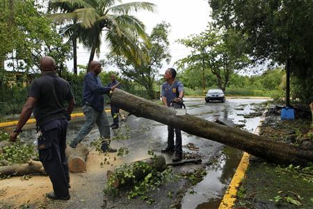 Emergencies management officials remove trees from a road after Hurricane Irene hit the municipality of Loiza, August 22, 2011 (Credit: Reuters/Ana Martinez)