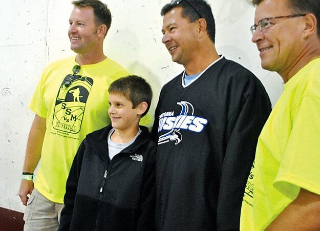 Nate Smith (second from left) and his dad Pat Smith (second from right) after his amazing 89-foot hockey shot. (Credit: Brendan Burnett-Kurie / AP)