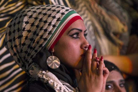 A Palestinian woman watches a public screening of Palestinian President Mahmoud Abbas' speech at the United Nations, in the West Bank city of Ramallah September 23, 2011. (Credit: Reuters/Darren Whiteside)