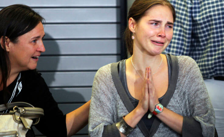 Amanda Knox (R) cries and gestures to friends while her mother Edda Mellas sits next to her during a news conference at Sea-Tac International Airport, Washington after Knox landed there on a flight from Italy, October 4, 2011. Knox returned home to Seattle on Tuesday, one day after an Italian court cleared the 24-year-old college student of murder and freed her from prison. (Credit: Reuters/Anthony Bolante)