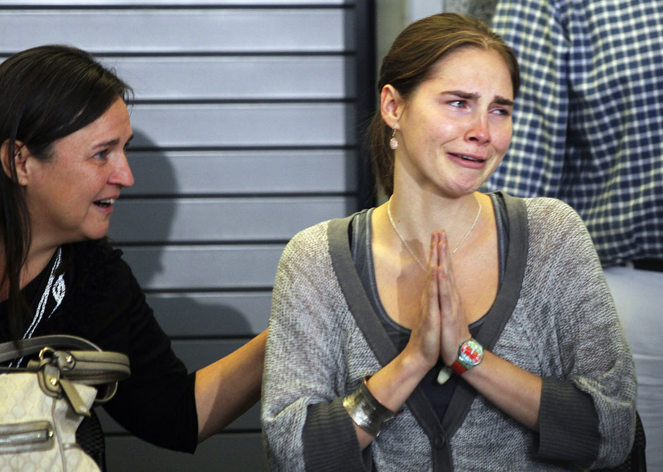 Amanda Knox (R) cries and gestures to friends while her mother Edda Mellas sits next to her during a news conference at Sea-Tac International Airport, Washington after Knox landed there on a flight from Italy, October 4, 2011. Knox returned home to Seattle on Tuesday, one day after an Italian court cleared the 24-year-old college student of murder and freed her from prison. (Credit: Reuters/Anthony Bolante)