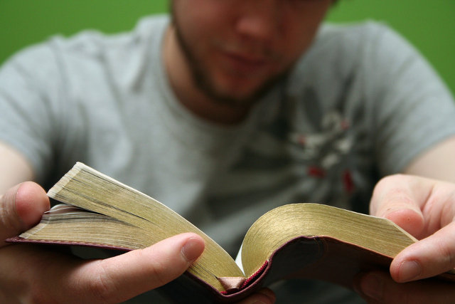 young man reading a small bible (Credit: Mele Avery via Fotolia)
