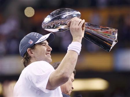 New York Giants quarterback Eli Manning raises the Vince Lombardi Trophy after defeating the New England Patriots to win the NFL Super Bowl XLVI football game in Indianapolis, Indiana, February 5, 2012 (Credit: Reuters/Matt Sullivan)