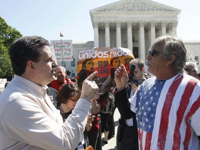 Mark Jenkins (L), an opponent of Arizona Senate Bill 1070 and Blake Sutherland, a supporter of the bill, discuss their opposite viewpoints outside the U.S. Supreme Court in Washington in this April 25 file photo (Credit: Reuters/Gary Cameron)