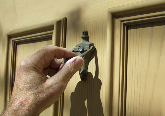hand on door knocker, knock on Gods door (Credit: Ken Tannenbaum via fotolia.com)