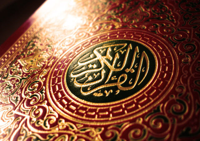 A closeup of the front of a Qur'an with a red leather cover (Credit: crystalina via en.wikipedia.org via Flickr)