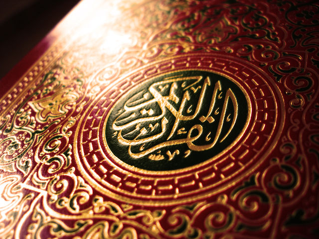 A closeup of the front of a Qur'an with a red leather cover (Credit: crystalina via en.wikipedia.org via Flickr)