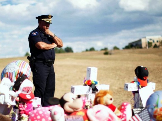 Aurora Colorado District 1 Commander Kevin Flynn looks at the memorial for the victims of the movie theater shooting in Aurora, July 25, 2012 (Credit: Reuters / Rick Wilking)