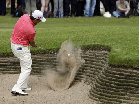 Graeme McDowell of Northern Ireland plays a shot out of the bunker on the second hole at Royal Lytham & St Annes golf club during the final round of the British Open Golf Championship, Lytham St Annes, England, July 22, 2012 (AP Photo/Chris Carlson)