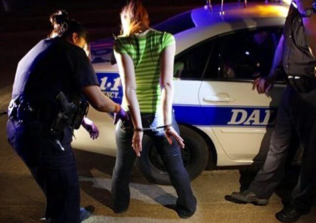 Police arrest a young woman for prostitution as part of an intervention program in Dallas (Credit: AP/ LM Otero)