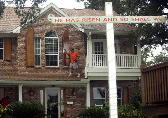 Jason Preston closes shutters on a house as Hurricane Isaac approaches Gulfport, Mississippi, August 28, 2012 (Credit: Reuters / Michael Spooneybarger)