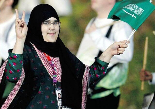 Saudi Arabia Wojdan Ali Seraj Abdulrahim Shaherkani gestures as she walks with the contingent in the atheletes parade during the opening ceremony of the London 2012 Olympic Games at the Olympic Stadium July 27, 2012 (Credit: Reuters / Suzanne Plunkett)