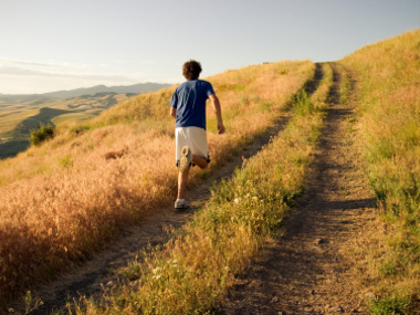 A young man running towards the crest of a hill (Credit: Forest Woodward Photography via iStockPhoto)