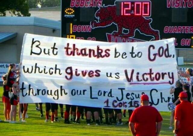 Kountze High School cheerleaders hold brea-kthru signs with Scripture verse on it before the start of a game Kountze High School football game. (Credit: Support Kountze Kids Faith facebook page)