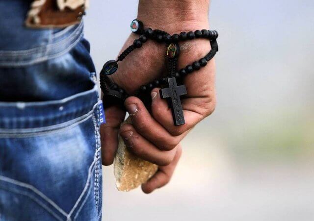 A Palestinian demonstrator wearing a rosary holds a stone during minor clashes with Israeli troops in protest against Israel's military operation in the Gaza Strip, in the West Bank village of Bir Zeit, near Ramallah, November 19, 2012 (Credit: Reuters/Mohamad Torokman)