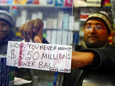 A worker pastes an updated Powerball sign up in New York, November 28, 2012 (Credit: Reuters/Carlo Allegri)
