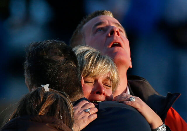 Family members of victims grieve near Sandy Hook Elementary School, where a gunman opened fire on school children and staff in Newtown, Conn., Dec. 14 (Credit: Catholic News Service / Adrees Latif )