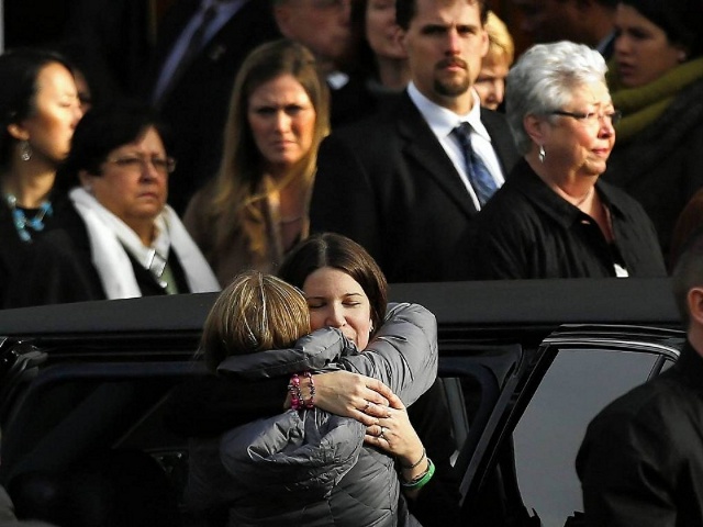 Krista Rekos, the mother of Sandy Hook Elementary school shooting victim Jessica Rekos, is embraced after her funeral at Saint Rose of Lima church in Newtown, Connecticut (Credit:Reuters/Shannon Stapleton)