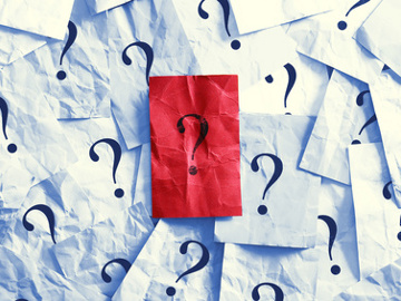 question marks on pieces of crumpled white paper with one crumpled red piece of paper in the middle (Credit: Stauke via Fotolia)