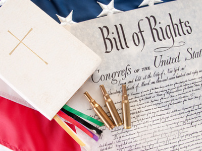 gun control: bullets, the Bill of Rights and a Bible on top of the US flag (Credit: Cheryl Casey)