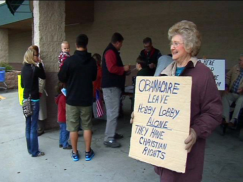 Aquilla King holds a sign outside a store in Mississpi supporting Hobby Lobby during Hobby Lobby Appreciation Day, January 5, 2013 (Credit: WDAM)