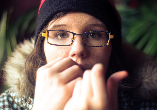 Young adult woman, Coffee House Clarice, nervously bites her fingernails (Credit: Maxwell GS via Flickr)
