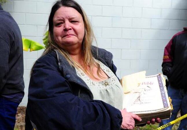 Wanda Carter holds a family bible which was recovered from the home where a sinkhole opened up underneath late it Thursday evening, swallowing Jeffrey Bush, in Seffner, Florida (Credit: Tampa Bay Online/Luke Johnson)