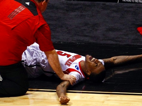 Trainers attend to Louisville's Kevin Ware (5) after he broke his leg in the first half against the Duke Blue Devils during their Midwest Regional NCAA men's basketball game in Indianapolis, Indiana, March 31, 2013 (Credit: Reuters/John Sommers II)