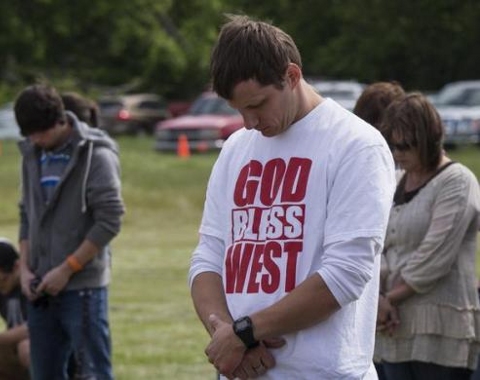 Town residents bow their heads in prayer during an open air Sunday church service four days after a deadly fertilizer plant explosion in the town of West, near Waco, Texas, April 21, 2013 (Credit: Reuters/Adress Latif)