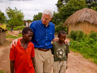 World Vision President Richard Stearns walks with two young boys through their village (Credit: Jon Warren/World Vision)
