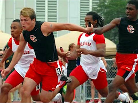 Columbus High School 4x100 relay team member Derrick Hayes takes the baton from teammate during a track meet (Credit: WFAA)