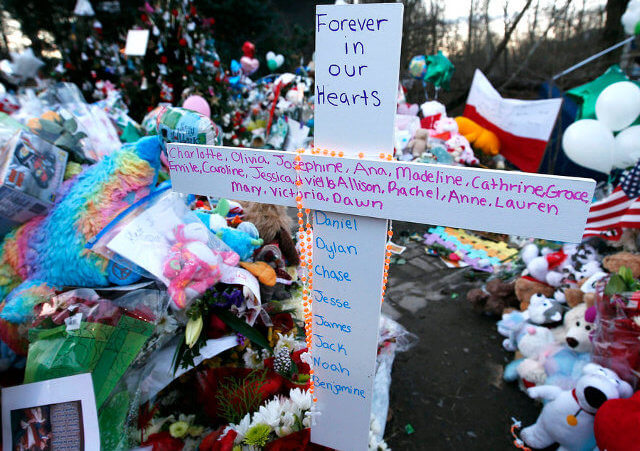 A cross bearing all the names of the victims of the shootings at Sandy Hook Elementary School in Newtown Connecticut December 14, stands at a makeshift memorial for victims of the shootings in Sandy Hook village in Newtown (Credit: Reuters/Mike Segar)