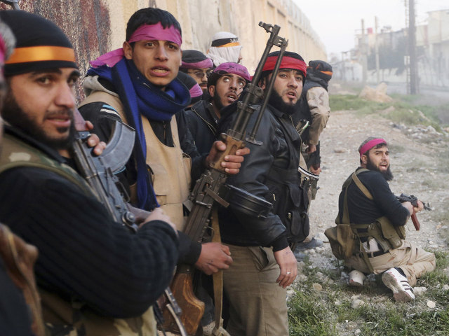 Free Syrian Army fighters taking cover as they prepare to join an attack on a Syrian Army base in Damascus on Feb. 3, 2013. (Credit: Goran Tomasevic/Reuters)