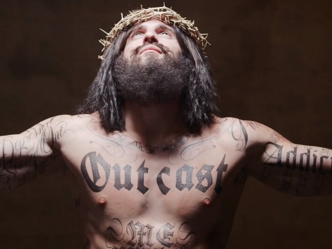 In a Jesus Tattoo video, Jesus is depicted sporting several tattoos -- including an oversize one on his chest reading Outcast (Credit: jesustattoo.org)