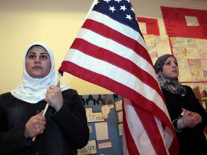 A young Muslim American female student holds the U.S. flag during a Children of the World student pageant at the Islamic Center of America in Dearborn, Michigan (Credit: Reuters/Rebecca Cook)