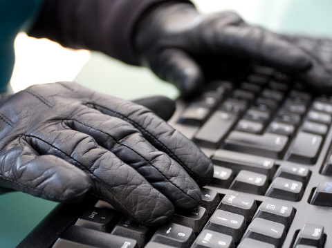 A person wearing black gloves at a keyboard, a concept design to illustrate the deep web, black market, and identity theft (Credit: hfox via Fotolia)