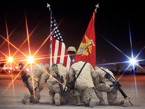 Marines kneel down beside the battlefield cross to pay their final respects to Sgt. Bradley Atwell, an aircraft electrical, instrument and flight control systems technician with Marine Aviation Logistics Squadron 16 who was killed in action during an attack on Camp Bastion in Afghanistan on Sep 14, during a memorial ceremony, Sep 20, 2012 (Credit: US Marines/Cpl. Mark Garcia)