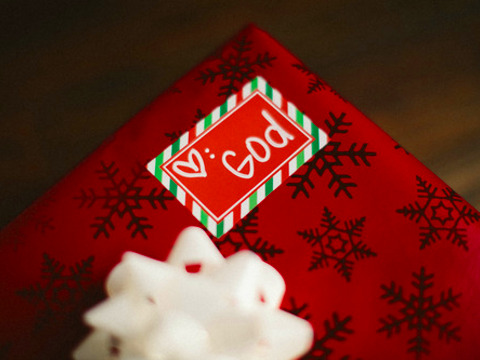 Christmas present with love from God, red wrapping paper with a white bow (Credit: Pearl via Lightstock)
