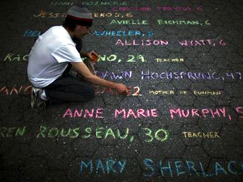 Street artist Mark Panzarino, 41, prepares a memorial as he writes the names of the Sandy Hook Elementary School victims during the six-month anniversary of the massacre, at Union Square in New York, June 14, 2013 (Credit: Reuters/Eduardo Munoz)