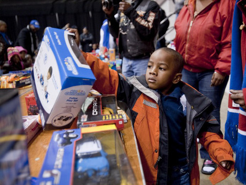 Caron Vinson, 4, picks out a police play set at the LJVM Coliseum annex Friday, December 21, 2012 as part of the Peace Toys for War Toys exchange program (Credit: Winston-Salem Journal/Lauren Carroll)